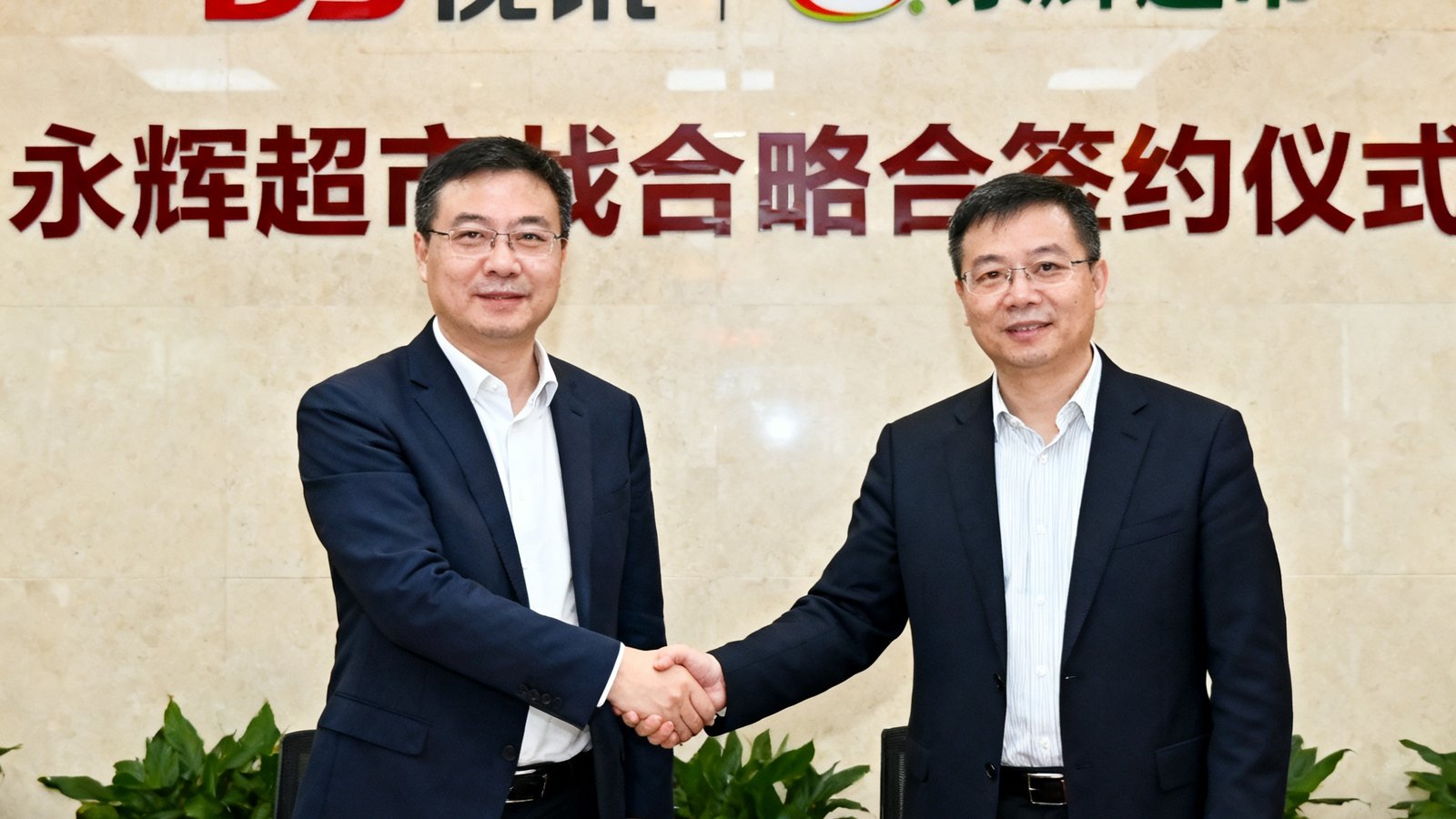 DS视讯与永辉超市战略合作签约仪式现场照片，双方代表在签约台握手，背后是品牌logo墙。